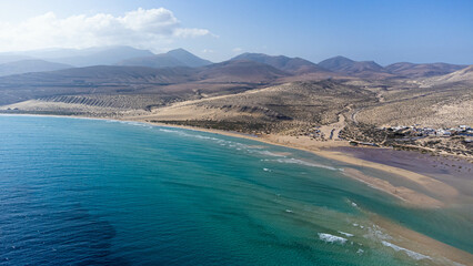 Aerial view of the Sotavento beach in the south of Fuerteventura in the Canary Islands, Spain - Sand strip in the Atlantic Ocean among a desertic barren landscape