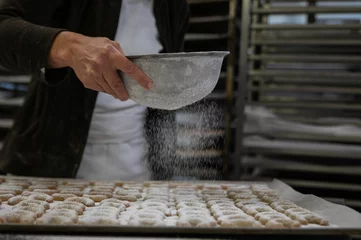 Raamstickers Cook adding powdered sugar to cookies as a topping © Nadja Knapp/Wirestock Creators