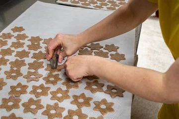 Zelfklevend Fotobehang Female hands making holes in biscuit dough © Nadja Knapp/Wirestock Creators