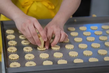 Wandcirkels aluminium Female hands making holes in biscuit dough © Nadja Knapp/Wirestock Creators