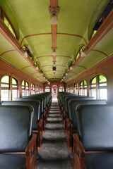 Vertical shot of an old bus interior with comfortable black seats