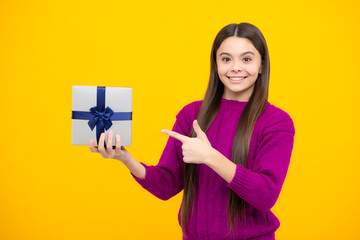 Teenager child with gift box, studio isolated background. Present for birthday, Valentines day, New Year or Christmas. Kid hold present box with gift ribbon bow.