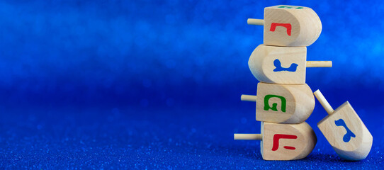 Jewish holiday Hanukkah concept. Wooden dreidel (spinning top) on blue background.