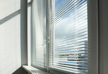 Stylish window with horizontal blinds in room