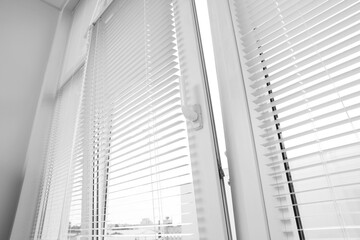 Stylish window with horizontal blinds in room, low angle view