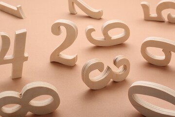 Many different wooden numbers on beige background