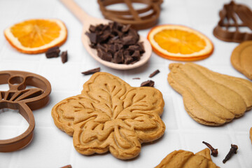 Different tasty cookies, spices and cutters on white table, closeup