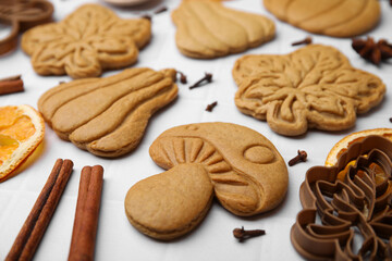 Different tasty cookies, spices and cutters on white table, closeup