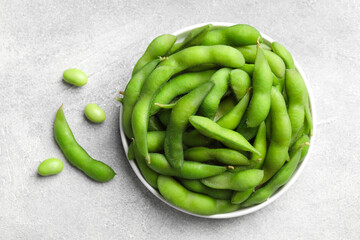 Green edamame beans in pods on light grey table, flat lay