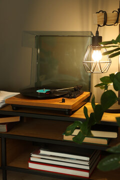 Stylish turntable with vinyl record on table indoors