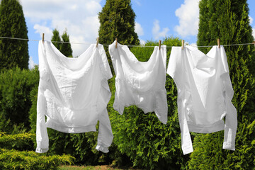 Clean clothes hanging on washing line in garden. Drying laundry