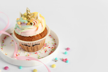 Cute sweet unicorn cupcake on white table, space for text