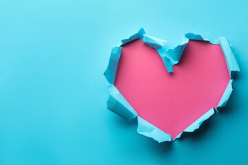 Naklejka na ściany i meble Torn heart shaped hole in light blue paper on pink background, space for text