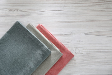 Different colorful napkins on white wooden table, top view. Space for text