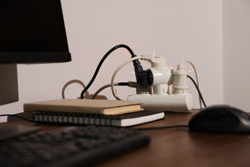 Inflamed plug in power strip indoors on wooden table. Electrical short circuit