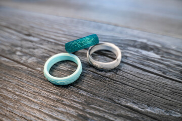 Selective focus on a set of three silicon rings on a wooden background