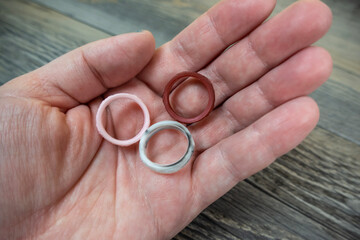 Selective focus on a set of three silicon rings on a wooden background
