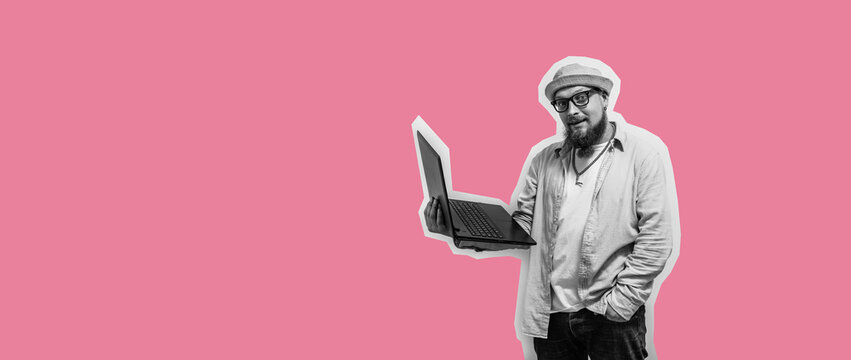 Young crazy bearded charismatic man. Shocked or surprised expression. Laptop concept. Funny promotion poster. Programmer, web developer holding a laptop in his hands and looking at the camera