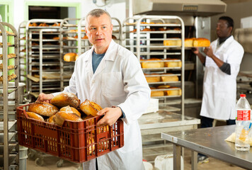Baker sorts finished products at the bakery. High quality photo