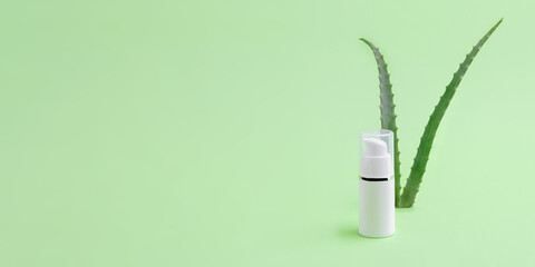 Blank cosmetics dispenser with aloe vera on background.Organic cosmetic concept.Large banner with negative space.