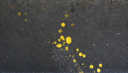 Black concrete with yellow paint spots background and wallpaper texture