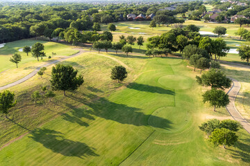 Obraz premium Top aerial view of beautiful park, green zone. Birds eye and drone photography of summer park. Nature landscape, green meadows in countryside in sunny day, beautiful green golf course.