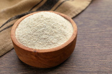 Quinoa flour in wooden bowl on wooden table