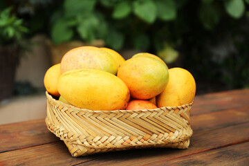 Delicious ripe juicy mangos on wooden table