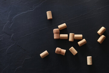 Wine bottle corks on black table, flat lay. Space for text