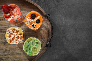 Tray with many different delicious smoothies on grey table, top view. Space for text