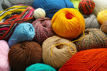 Different balls of woolen knitting yarns as background, closeup