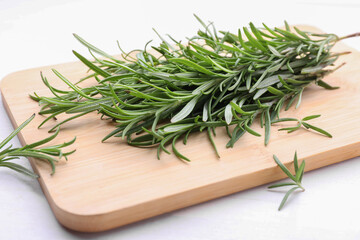 Fresh green rosemary twigs on white wooden table, closeup
