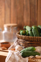Fresh cucumbers and other ingredients prepared for canning on wooden table
