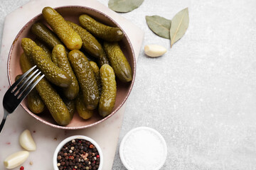 Fork with bowl of pickled cucumbers and ingredients on light grey table, flat lay. Space for text