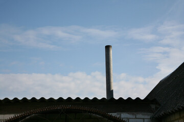 Roof with a chimney against the blue sky close-up