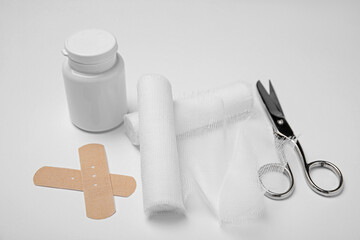Bandage rolls and medical supplies on white background
