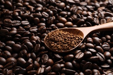 Spoon with instant coffee on roasted beans, closeup. Space for text