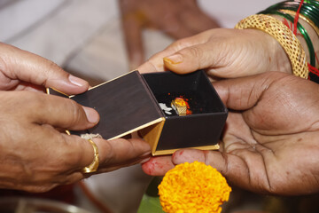 person holding a wedding ring with box in Indian Hindu religion wedding ceremony 