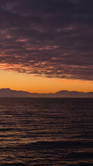 Obraz premium Popcorn clouds illuminated pink over the silhouette of a mountain, at sunset at Cierva Cove, Antarctica