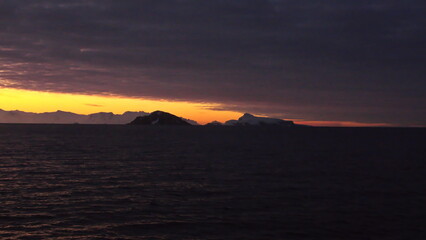 Sunset over the silhouette of mountains at Cierva Cove, Antarctica