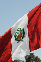 Peru national flag cloth fabric waving on beautiful sky.
