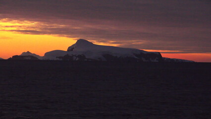 Obraz premium Sunset over the silhouette of mountains at Cierva Cove, Antarctica