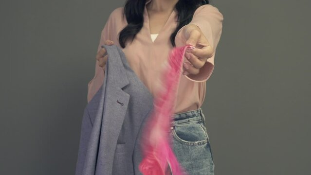 Woman takes out panties from her husband's or boyfriend's jacket pocket. Adultery and divorce concept. Evidence found.