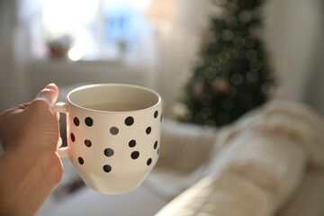 Woman with cup of cocoa indoors, closeup. Christmas mood