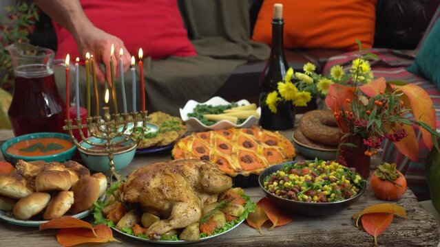 Hanukkah dinner. Jewish Man with Family lighting Hanukkah Candles in a menorah for the holidays