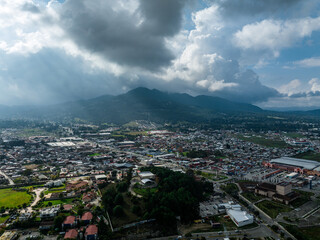 Obraz premium Aerial view of a large mountain at sunset with sun rays breaking through the clouds. The beautiful city San Cristóbal de Las Casas in Mexico.