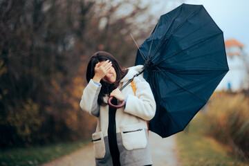 Woman with Broken Umbrella Walking in a Storm. Stressed girl trying to go home during bad weather...