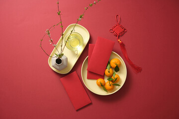 Red background decorations included lucky money, Mandarin oranges, tea, a vase of flowers, and...