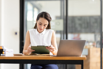 Portrait of tired young business Asian woman work with documents tax laptop computer in office. Sad, unhappy, Worried, Depression, or employee life stress concept