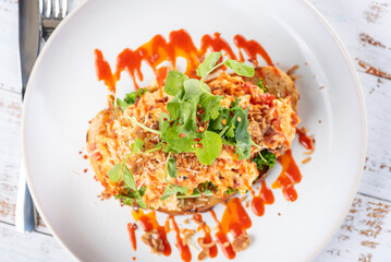 A serving of Chilli Scramble, scrambled eggs with sweet chilli sauce and a piece of toasted sourdough bread